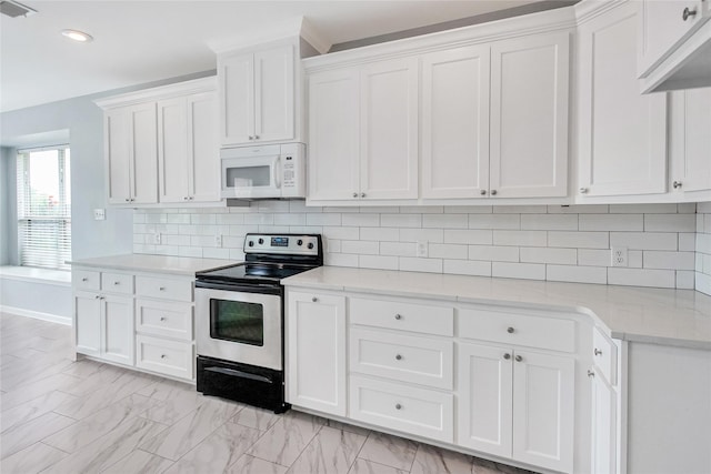 5718 Gloucester Dr, Tyler, TX 75707 - kitchen featuring stainless steel range with electric cooktop, white microwave, white cabinets, tasteful backsplash, and recessed lighting