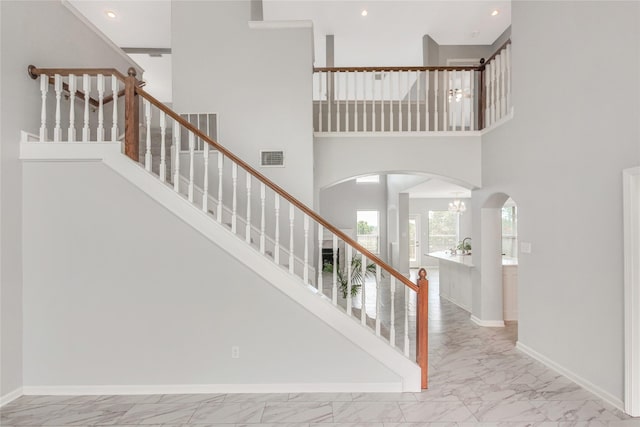 5718 Gloucester Dr, Tyler, TX 75707 - staircase featuring marble finish flooring, arched walkways, a chandelier, baseboards, and recessed lighting