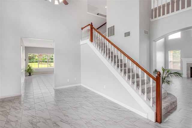 5718 Gloucester Dr, Tyler, TX 75707 - stairs with a high ceiling, marble finish flooring, a ceiling fan, baseboards, and a fireplace
