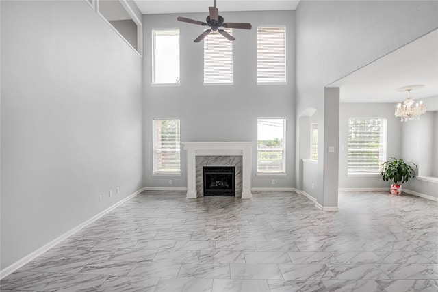 5718 Gloucester Dr, Tyler, TX 75707 - unfurnished living room with marble look tiles, a ceiling fan, a fireplace, baseboards, and a chandelier