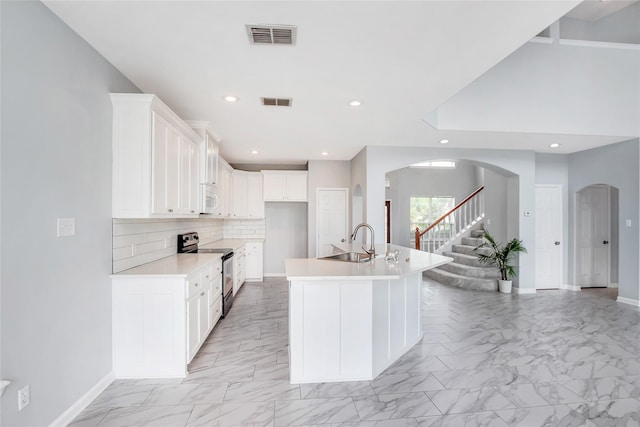5718 Gloucester Dr, Tyler, TX 75707 - kitchen with stainless steel electric range oven, a sink, light marble finish floors, white microwave, and recessed lighting