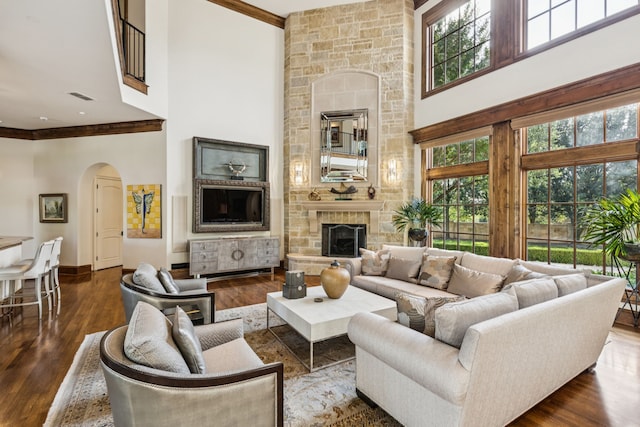 5112 Palomar Ln, Dallas, TX 75229 - living area featuring a towering ceiling, a fireplace, arched walkways, dark wood-style flooring, and crown molding