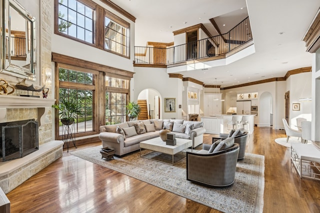 5112 Palomar Ln, Dallas, TX 75229 - living area with arched walkways, a towering ceiling, healthy amount of natural light, a fireplace with raised hearth, and wood finished floors