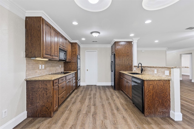 1458 Foxwood Ln, Rockwall, TX 75032 - kitchen with black appliances, a sink, light wood-style floors, decorative backsplash, and baseboards