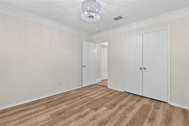 1458 Foxwood Ln, Rockwall, TX 75032 - unfurnished bedroom with a chandelier, wood finished floors, crown molding, a closet, and baseboards
