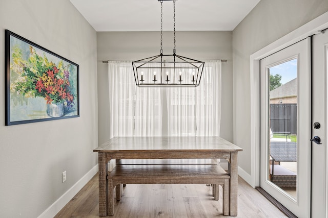 8620 Quail Meadow Dr, Irving, TX 75063 - dining room featuring a chandelier, light wood-style flooring, and baseboards