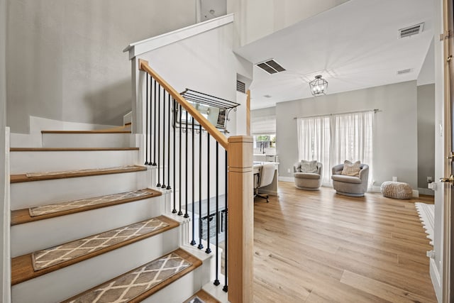 8620 Quail Meadow Dr, Irving, TX 75063 - stairs with wood finished floors, a high ceiling, and a chandelier