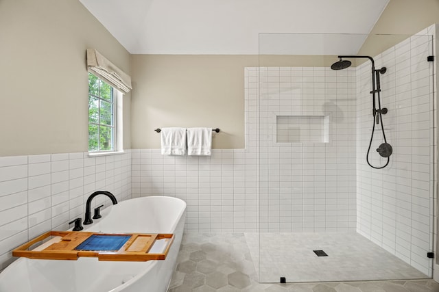 8620 Quail Meadow Dr, Irving, TX 75063 - bathroom with tile walls, tiled shower, a soaking tub, a wainscoted wall, and tile patterned floors