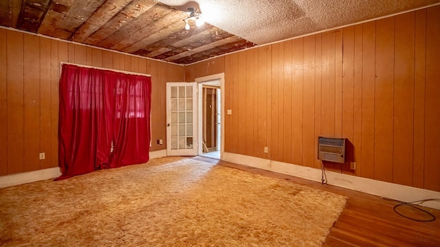 224 Pecan St, Dublin, TX 76446 - unfurnished room featuring heating unit, wood walls, and wood finished floors