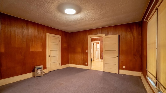 224 Pecan St, Dublin, TX 76446 - carpeted spare room with wooden walls, a textured ceiling, and baseboards