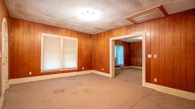 224 Pecan St, Dublin, TX 76446 - unfurnished room with attic access, a textured ceiling, wooden walls, and carpet floors