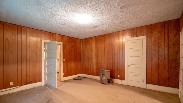 224 Pecan St, Dublin, TX 76446 - carpeted empty room featuring wood walls, a textured ceiling, and heating unit