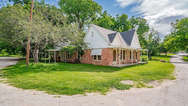 224 Pecan St, Dublin, TX 76446 - view of home's exterior featuring a porch, a lawn, and brick siding