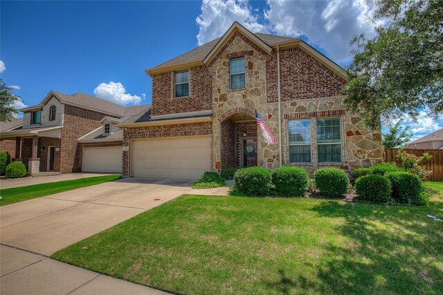 189 Charleston Ln, Fate, TX 75189 - view of front facade featuring stone siding, concrete driveway, an attached garage, and brick siding