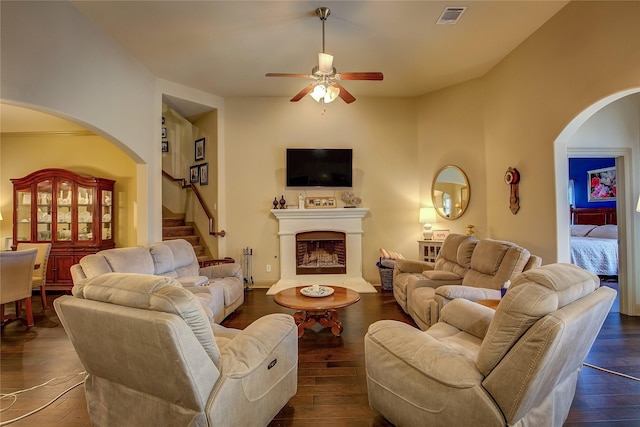 189 Charleston Ln, Fate, TX 75189 - living room featuring arched walkways, ceiling fan, dark wood-style flooring, and a fireplace with raised hearth