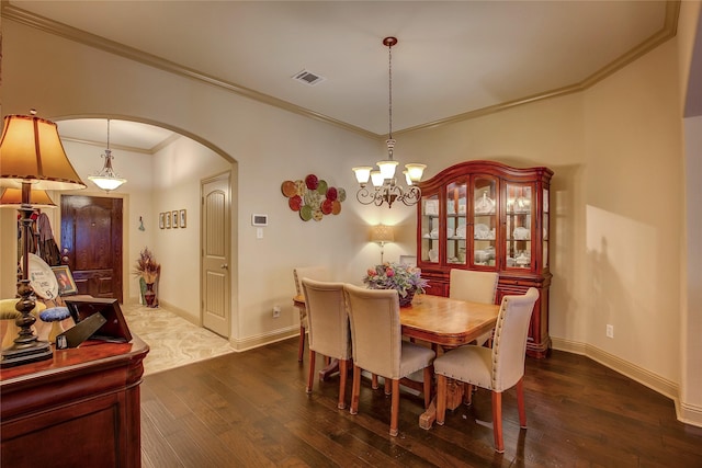 189 Charleston Ln, Fate, TX 75189 - dining area featuring arched walkways, dark wood-type flooring, ornamental molding, a chandelier, and baseboards