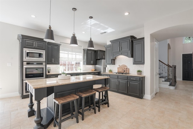8008 Craftsbury Ln, Mckinney, TX 75071 - kitchen featuring arched walkways, stainless steel appliances, a center island, recessed lighting, and pendant lighting