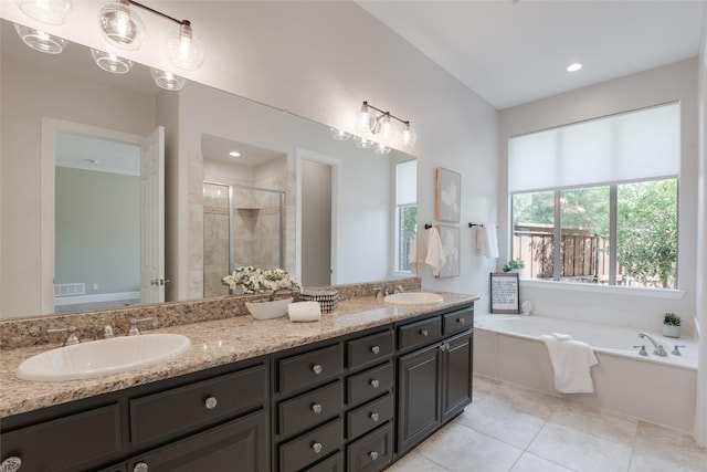 8008 Craftsbury Ln, Mckinney, TX 75071 - bathroom with double vanity, a shower stall, a garden tub, and tile patterned floors