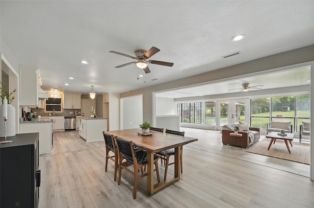 1700 N Preston St, Ennis, TX 75119 - dining area featuring ceiling fan, light wood-type flooring, recessed lighting, french doors, and a textured ceiling