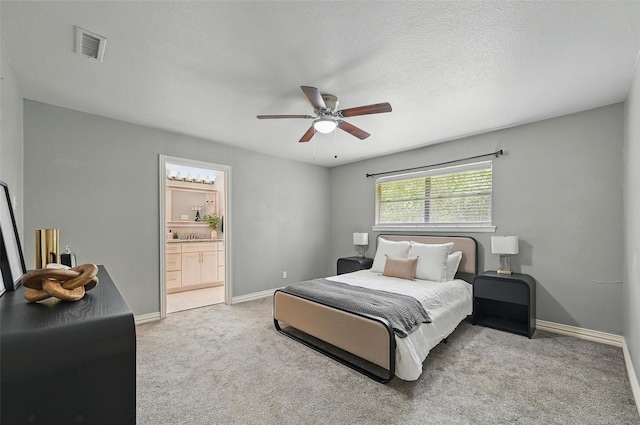 1700 N Preston St, Ennis, TX 75119 - bedroom featuring light carpet, ensuite bathroom, and a ceiling fan