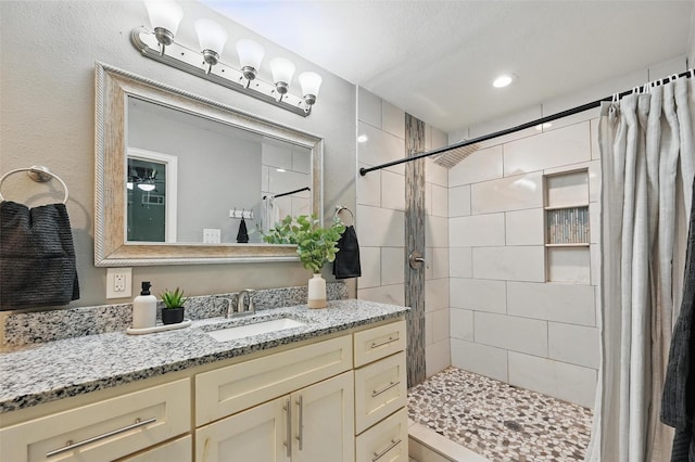 1700 N Preston St, Ennis, TX 75119 - bathroom with a tile shower, vanity, and recessed lighting