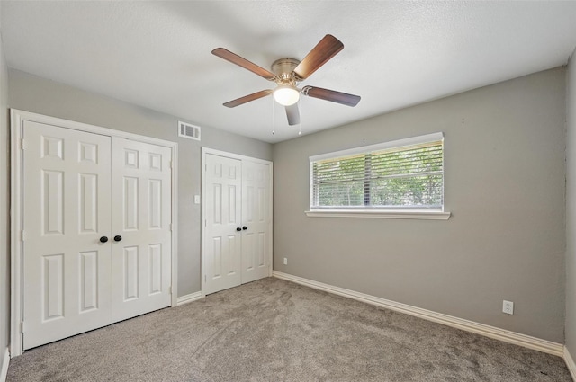 1700 N Preston St, Ennis, TX 75119 - unfurnished bedroom with multiple closets, carpet floors, and ceiling fan