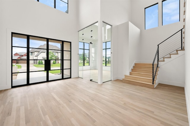 1106 Knoll Crest Dr, Mansfield, TX 76063 - unfurnished living room featuring plenty of natural light, a towering ceiling, stairs, and wood finished floors