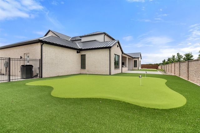 1106 Knoll Crest Dr, Mansfield, TX 76063 - back of house with a standing seam roof, a putting green, brick siding, and metal roof