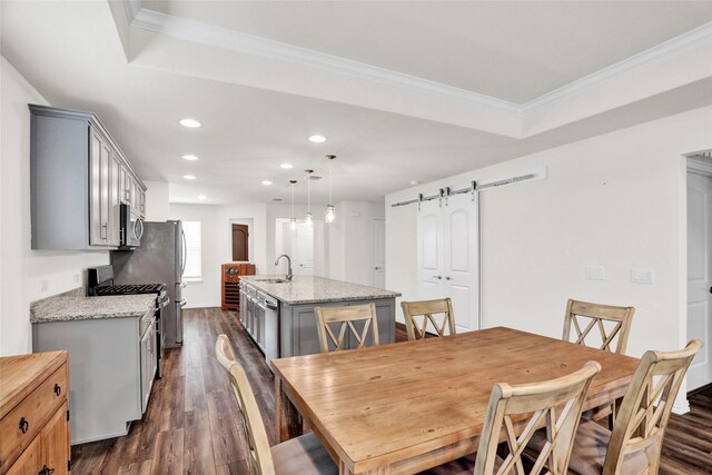 7668 Monument Dr, Little Elm, TX 76227 - dining space with a barn door, dark wood-style flooring, recessed lighting, and ornamental molding