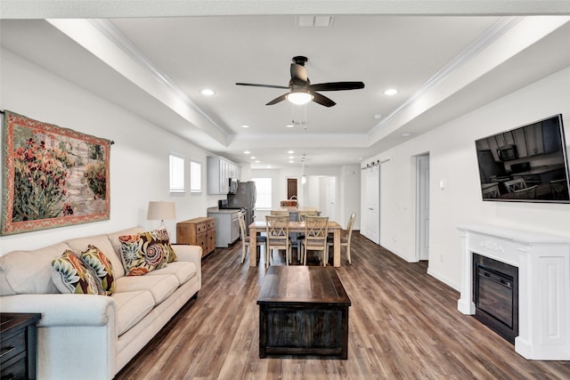 7668 Monument Dr, Little Elm, TX 76227 - living room with ornamental molding, a ceiling fan, a raised ceiling, wood finished floors, and recessed lighting