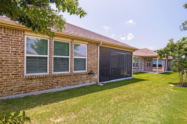 7668 Monument Dr, Little Elm, TX 76227 - back of property featuring brick siding, a lawn, a sunroom, and a shingled roof