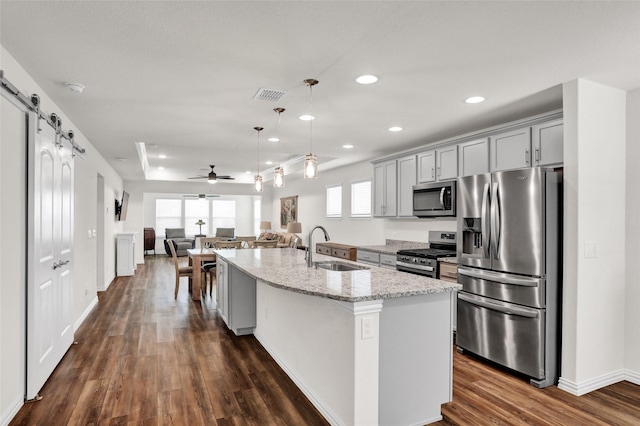 7668 Monument Dr, Little Elm, TX 76227 - kitchen featuring stainless steel appliances, gray cabinetry, recessed lighting, a center island with sink, and dark wood-type flooring