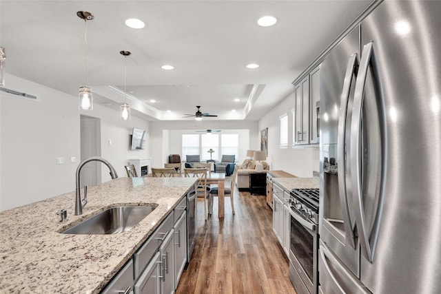 7668 Monument Dr, Little Elm, TX 76227 - kitchen with stainless steel appliances, a tray ceiling, ceiling fan, gray cabinetry, and recessed lighting