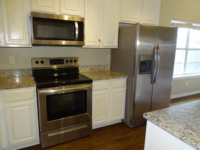 2013 Alanbrooke Dr, Fort Worth, TX 76140 - kitchen with appliances with stainless steel finishes, white cabinets, dark wood-style flooring, and light stone counters
