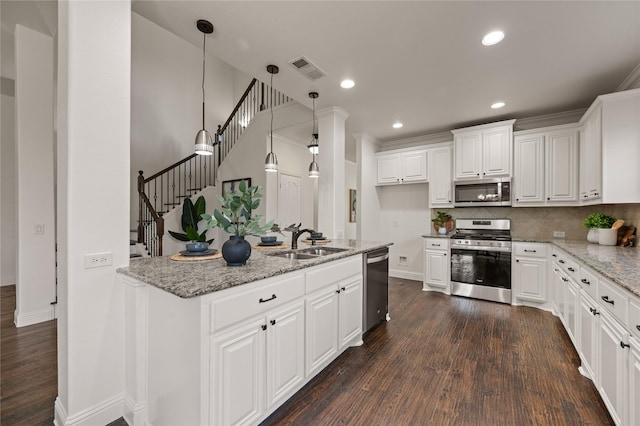 1021 Tara Dr, Burleson, TX 76028 - kitchen with appliances with stainless steel finishes, dark wood finished floors, decorative backsplash, white cabinetry, and recessed lighting