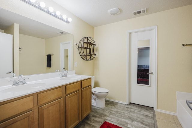 3428 Baby Doe Ct, Fort Worth, TX 76137 - full bath featuring double vanity, toilet, a bath, wood finished floors, and baseboards