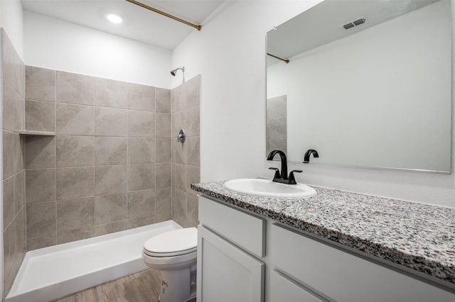 6851 Coulter Dr, Princeton, TX 75407 - bathroom featuring vanity, a tile shower, wood finished floors, and recessed lighting