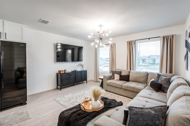 6851 Coulter Dr, Princeton, TX 75407 - living area with light wood-style floors and a chandelier