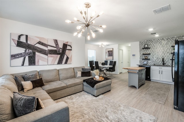 6851 Coulter Dr, Princeton, TX 75407 - living area with a chandelier and light wood-style floors
