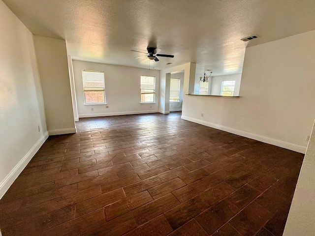 2056 Pecan Creek Dr, Mesquite, TX 75181 - unfurnished living room with ceiling fan, healthy amount of natural light, dark wood-type flooring, a textured ceiling, and baseboards