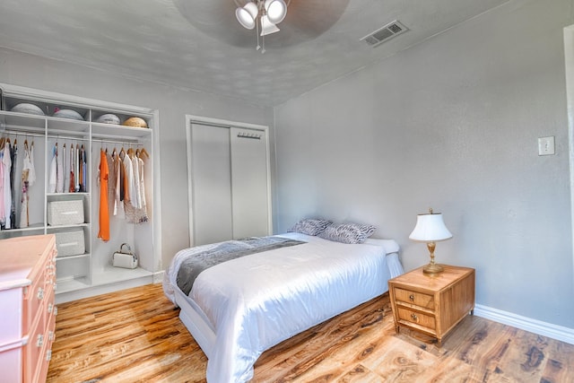 517 Pleasant Oaks Dr, Dallas, TX 75217 - bedroom featuring two closets, baseboards, wood finished floors, and a ceiling fan