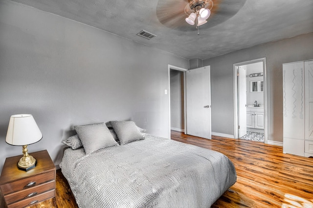 517 Pleasant Oaks Dr, Dallas, TX 75217 - bedroom featuring wood finished floors, baseboards, connected bathroom, and ceiling fan