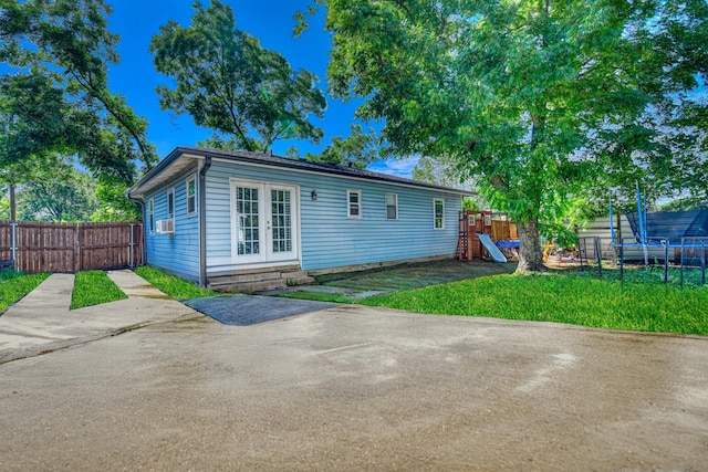 517 Pleasant Oaks Dr, Dallas, TX 75217 - back of house with french doors, a playground, a trampoline, a patio, and entry steps