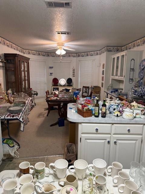 502 E College St, Leonard, TX 75452 - kitchen featuring ceiling fan, white cabinetry, a textured ceiling, light countertops, and carpet flooring