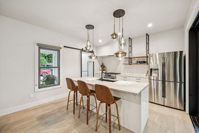 1921 Washington Ave, Fort Worth, TX 76110 - kitchen featuring stainless steel fridge, white cabinetry, tasteful backsplash, an island with sink, and a breakfast bar