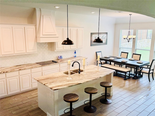 701 Winecup Way, Midlothian, TX 76065 - kitchen featuring black electric cooktop, backsplash, light wood-style floors, a sink, and premium range hood