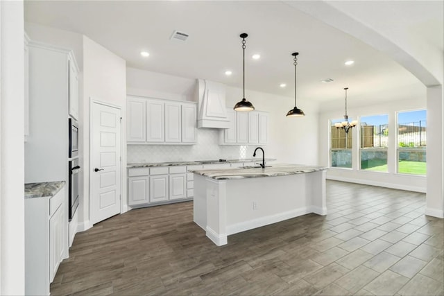 701 Winecup Way, Midlothian, TX 76065 - kitchen with custom exhaust hood, white cabinets, tasteful backsplash, a chandelier, and a sink