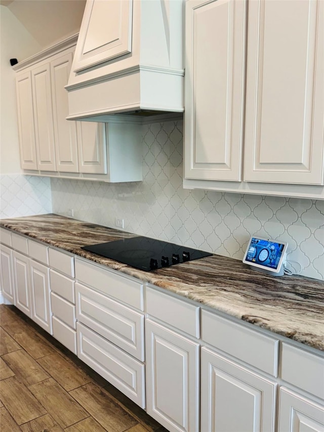 701 Winecup Way, Midlothian, TX 76065 - kitchen with premium range hood, black electric cooktop, white cabinetry, and tasteful backsplash