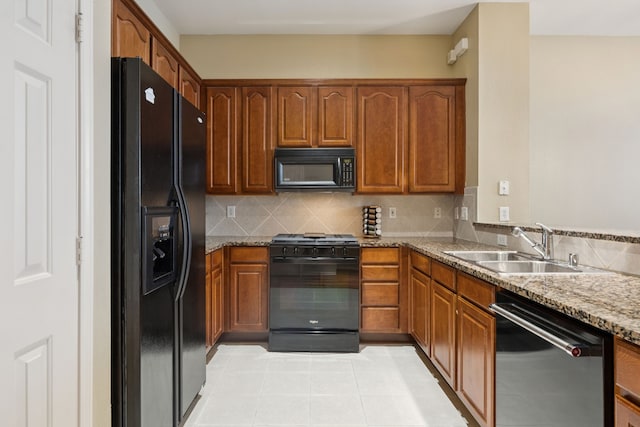 4121 Mckinney Ave Unit 21, Dallas, TX 75204 - kitchen with black appliances, light stone countertops, tasteful backsplash, brown cabinets, and light tile patterned floors
