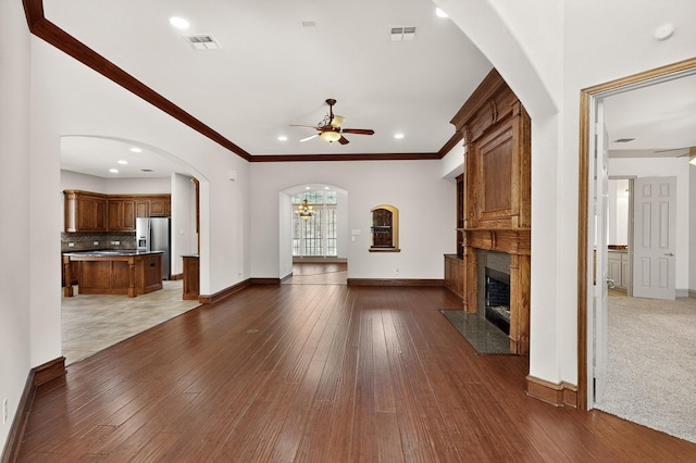 5766 Wellington Ln, Frisco, TX 75033 - unfurnished living room with ceiling fan, a fireplace, arched walkways, hardwood / wood-style flooring, and recessed lighting